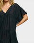 Black tiered dress worn by a person on a plain background