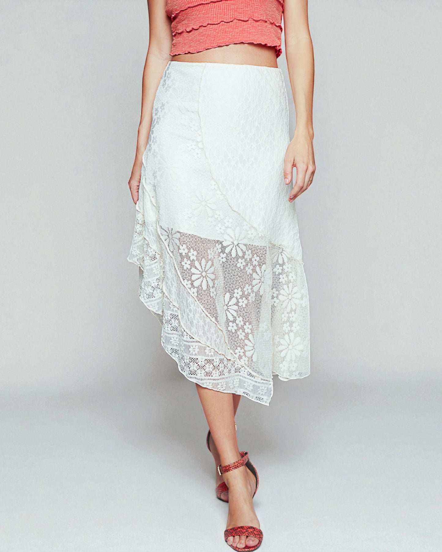 White lace skirt worn by a person on a plain background