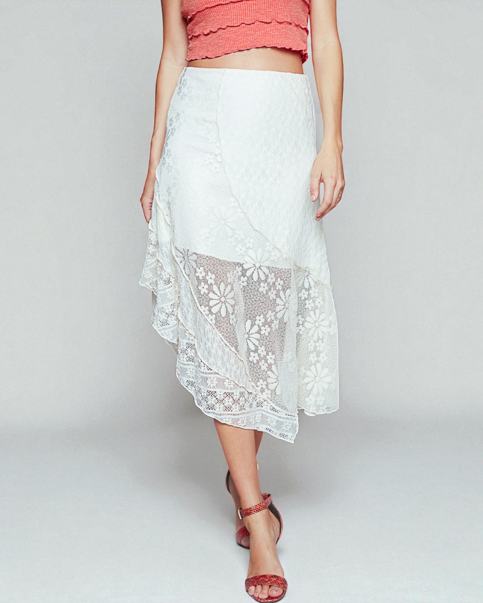 White lace skirt worn by a person on a plain background