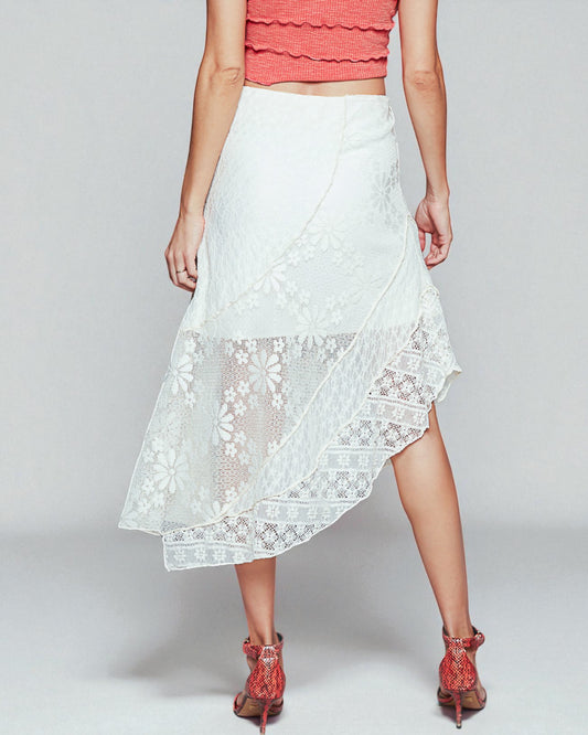 White lace skirt worn by a person on a plain background