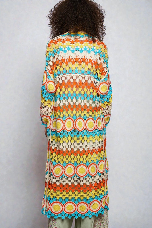 Person wearing a colorful patterned dress against a plain background