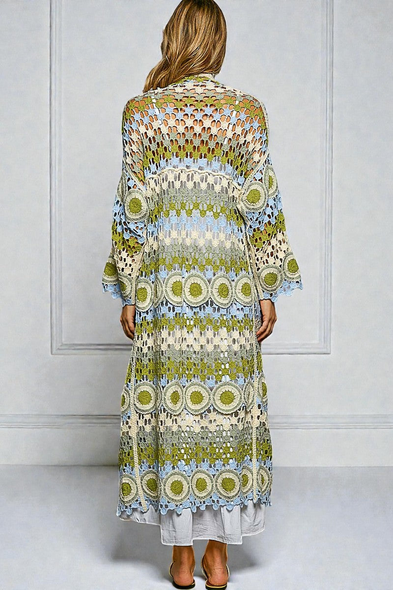 Woman wearing a long, patterned dress against a white wall.