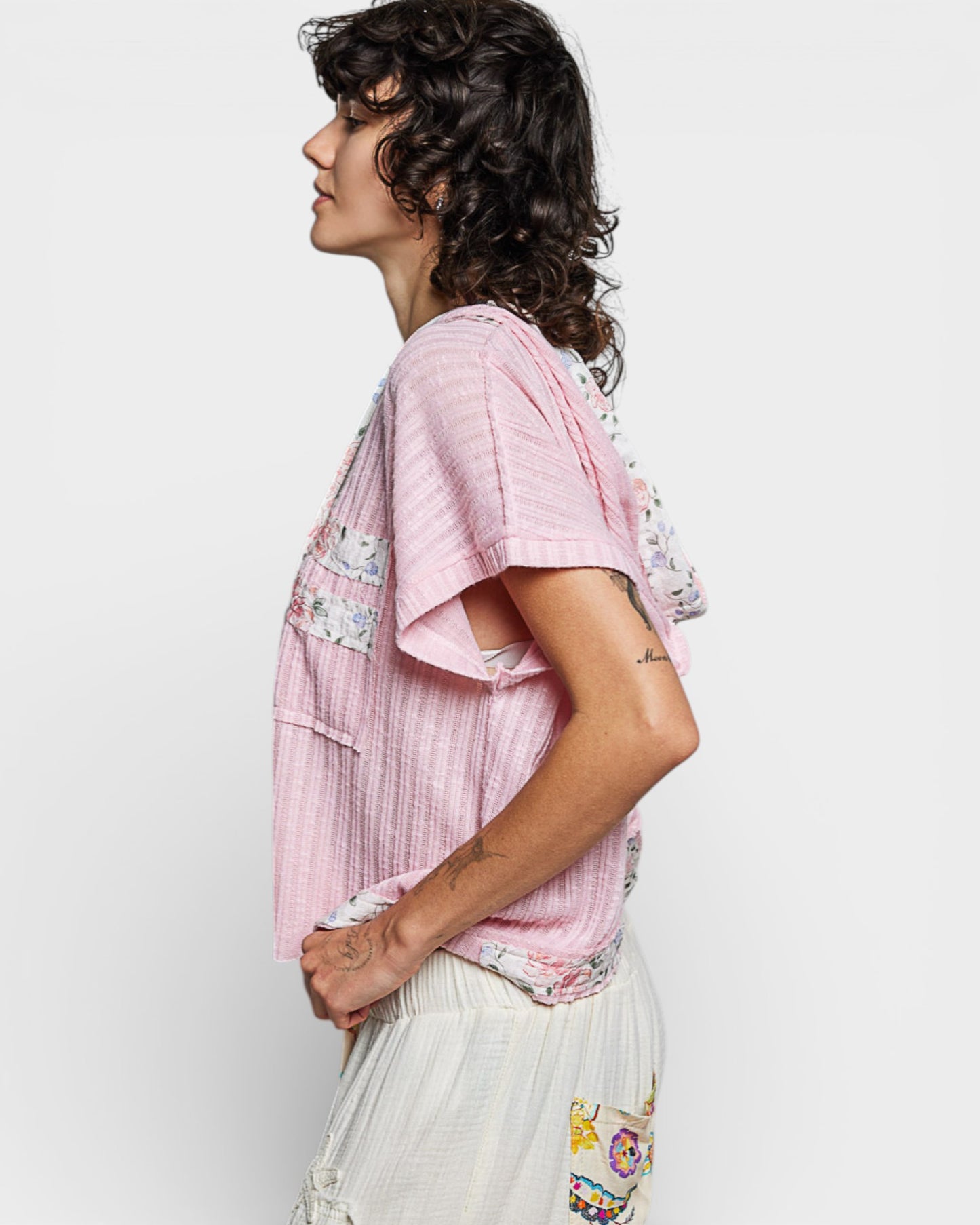 Person wearing a pink floral blouse with a white background