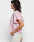 Person wearing a pink floral blouse with a white background