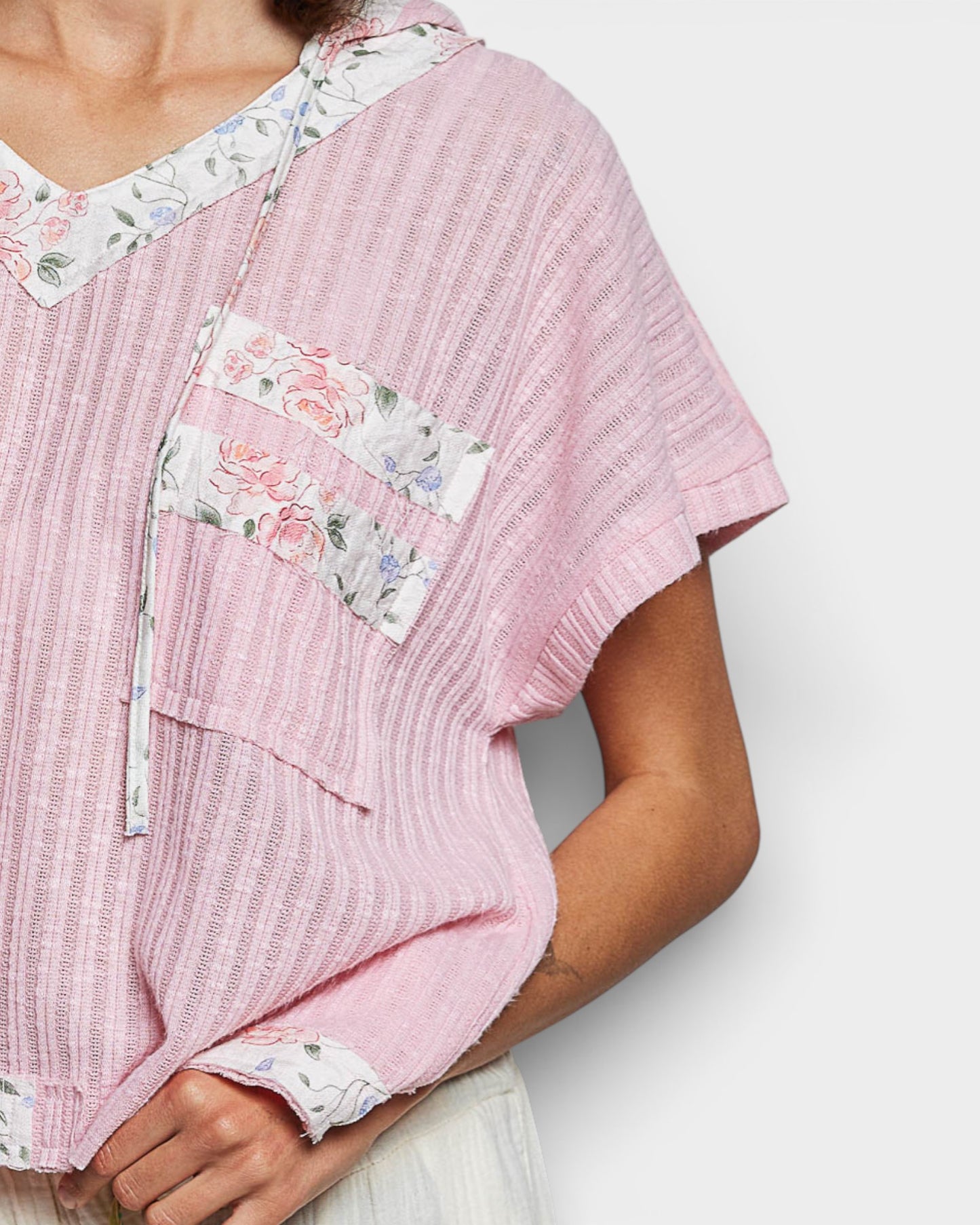 Pink textured top with floral patterns on a white background