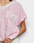 Pink textured top with floral patterns on a white background