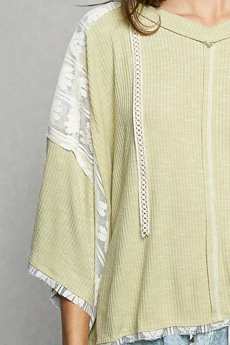 Light green textured top with white lace trim on a gray background