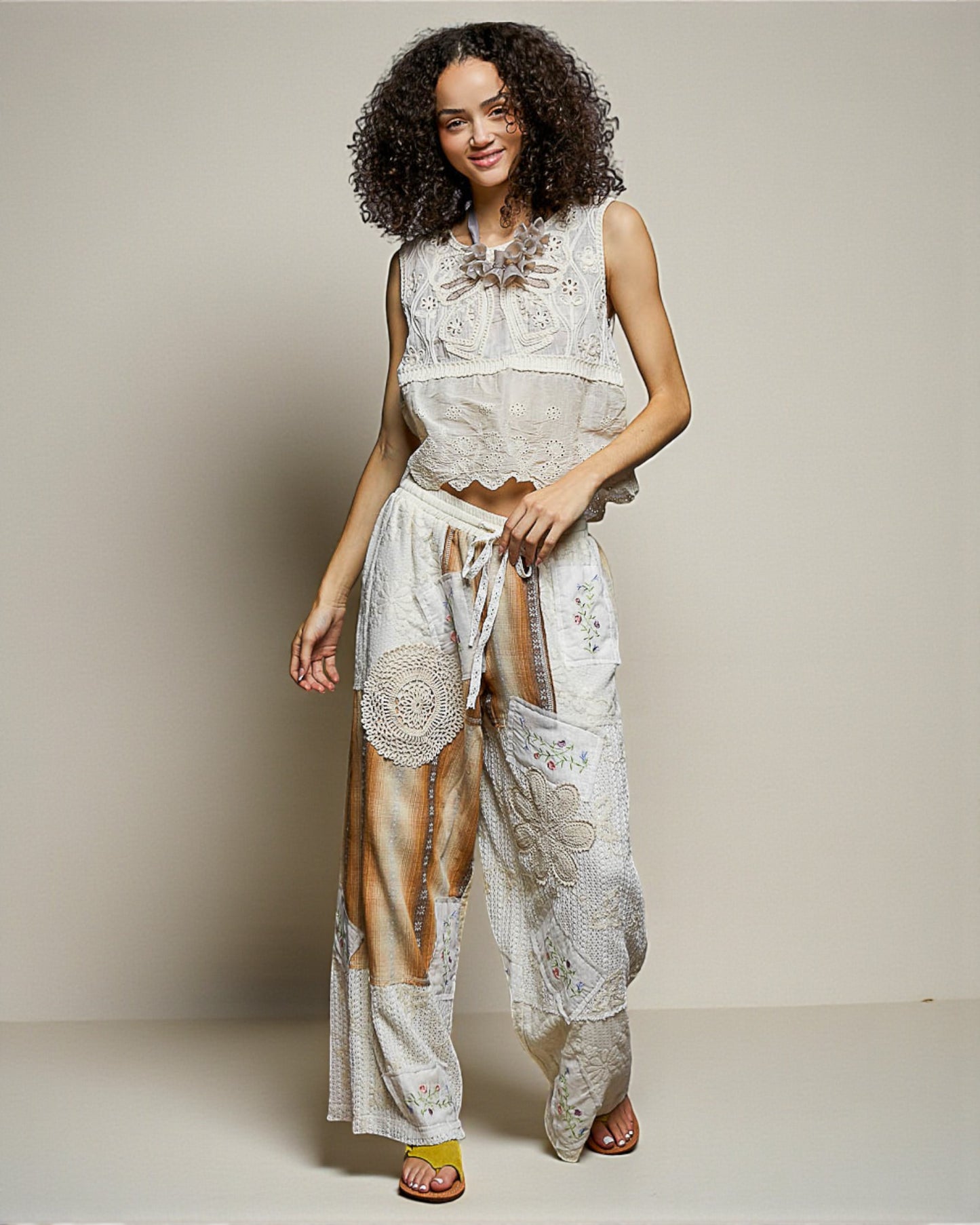 Woman wearing a white lace outfit with a neutral background