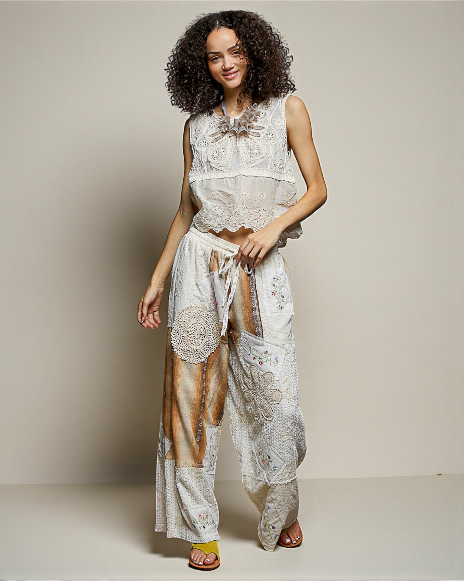 Woman wearing a white lace outfit with a neutral background