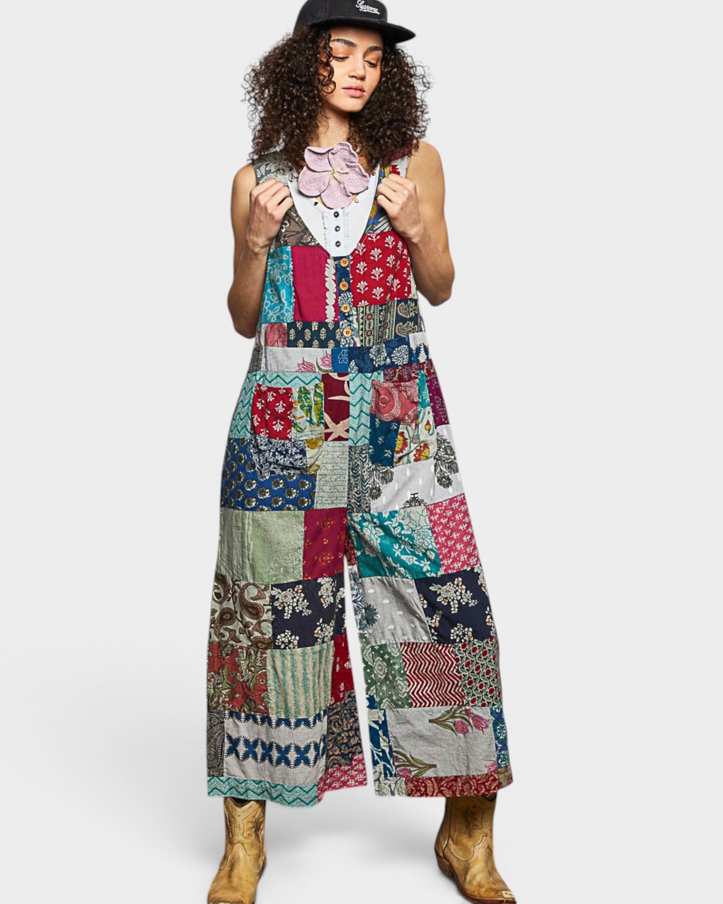 Woman wearing a colorful patchwork jumpsuit on a white background