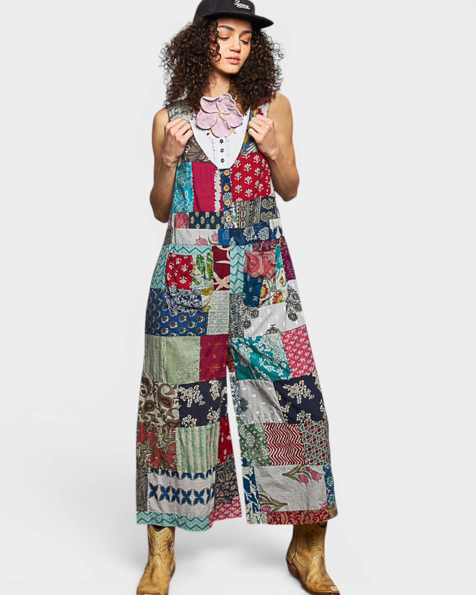 Woman wearing a colorful patchwork jumpsuit on a white background