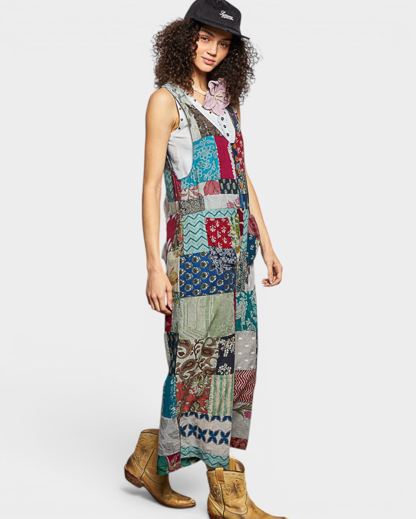 Woman wearing a colorful patchwork jumpsuit on a white background