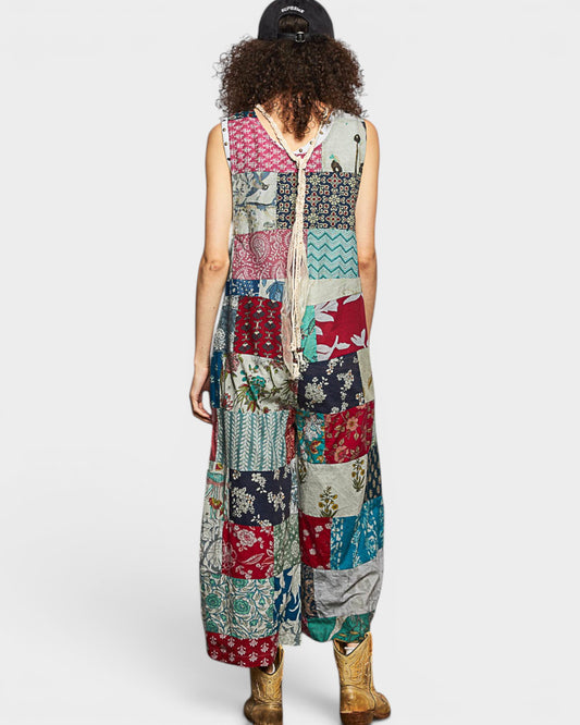 Person wearing a colorful patchwork jumpsuit on a white background