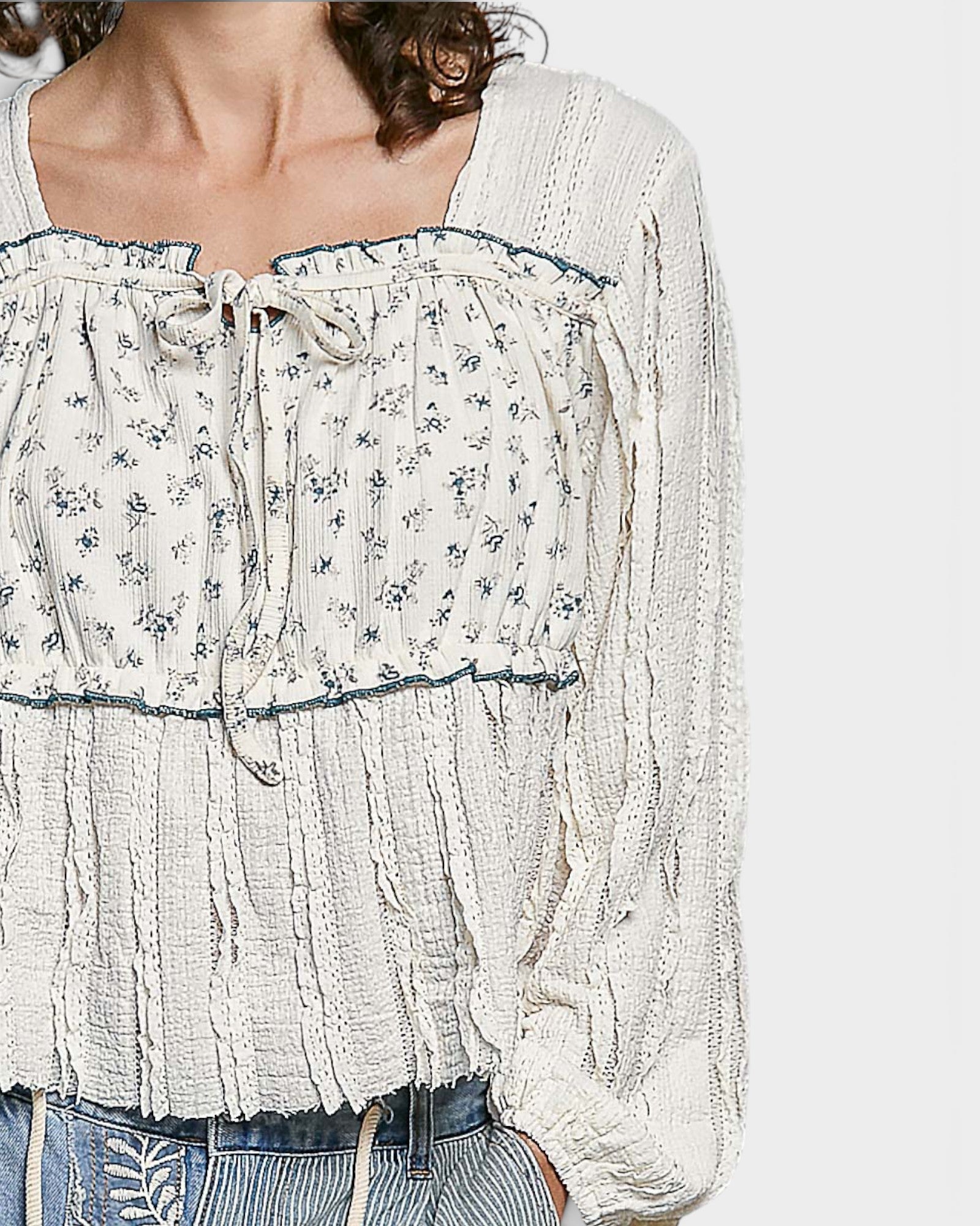 White floral blouse with long sleeves on a white background