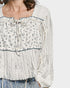 White floral blouse with long sleeves on a white background