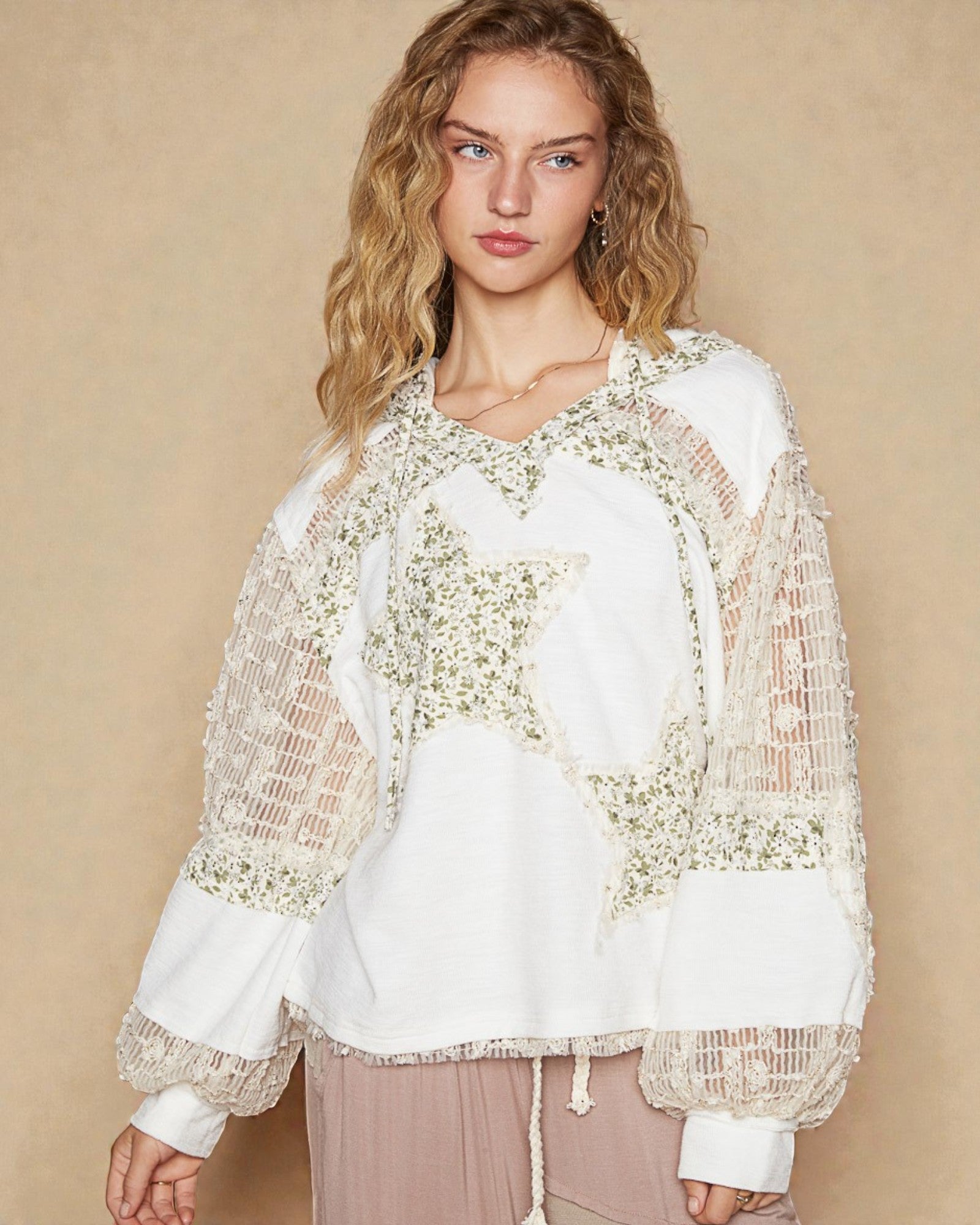 Woman wearing a white blouse with floral lace details on a beige background