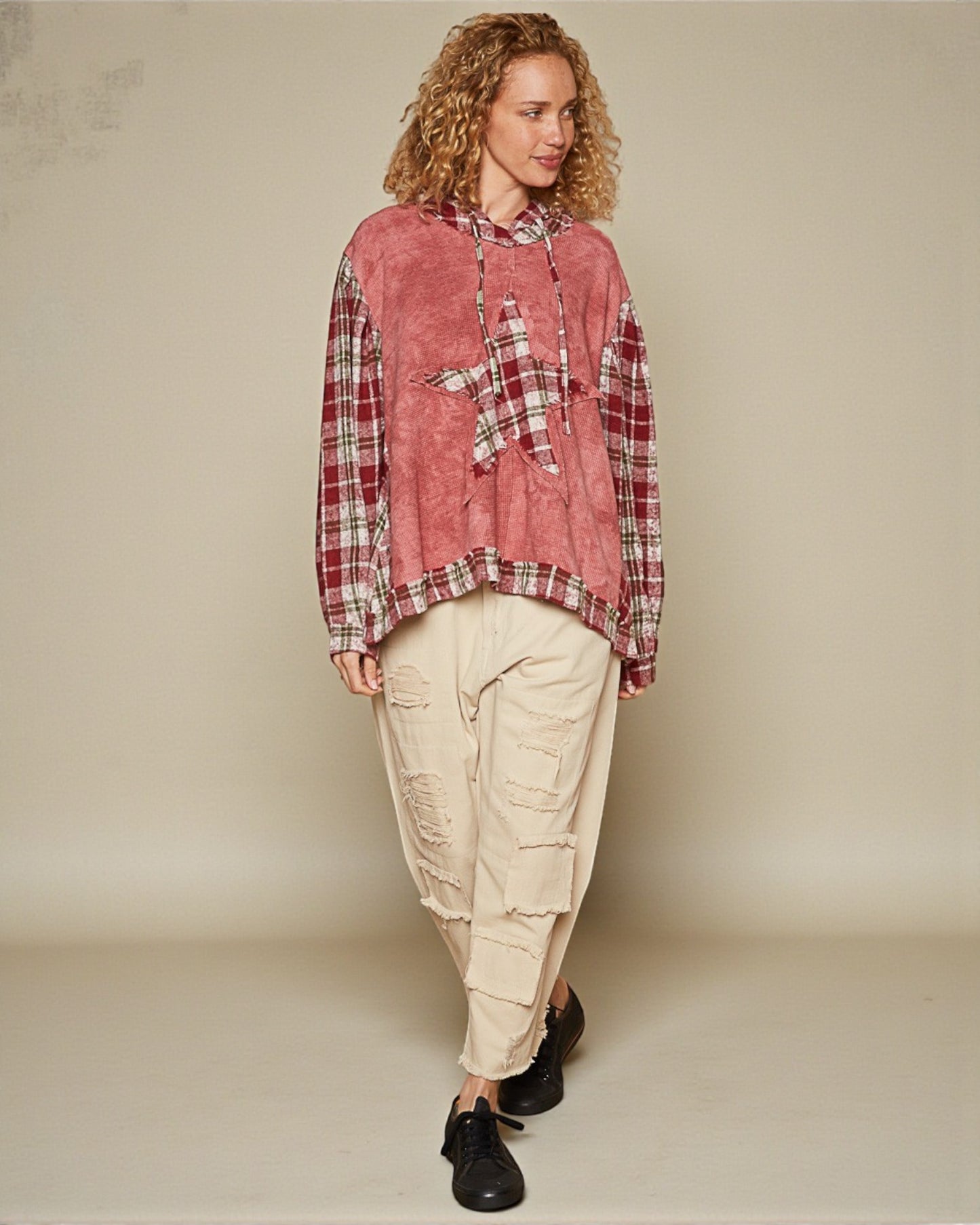 Person wearing a red plaid shirt and beige cargo pants on a plain background