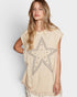 Woman wearing a beige tunic with a star design on a white background