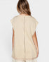 Woman wearing a beige sleeveless top with sheer overlay on a white background