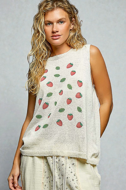 Woman wearing a sleeveless top with strawberry pattern against a gray background