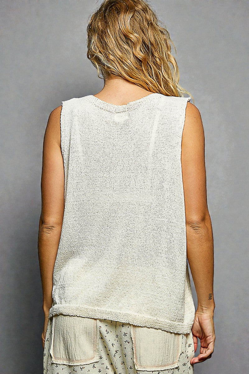 Person wearing a sleeveless top with a gray background