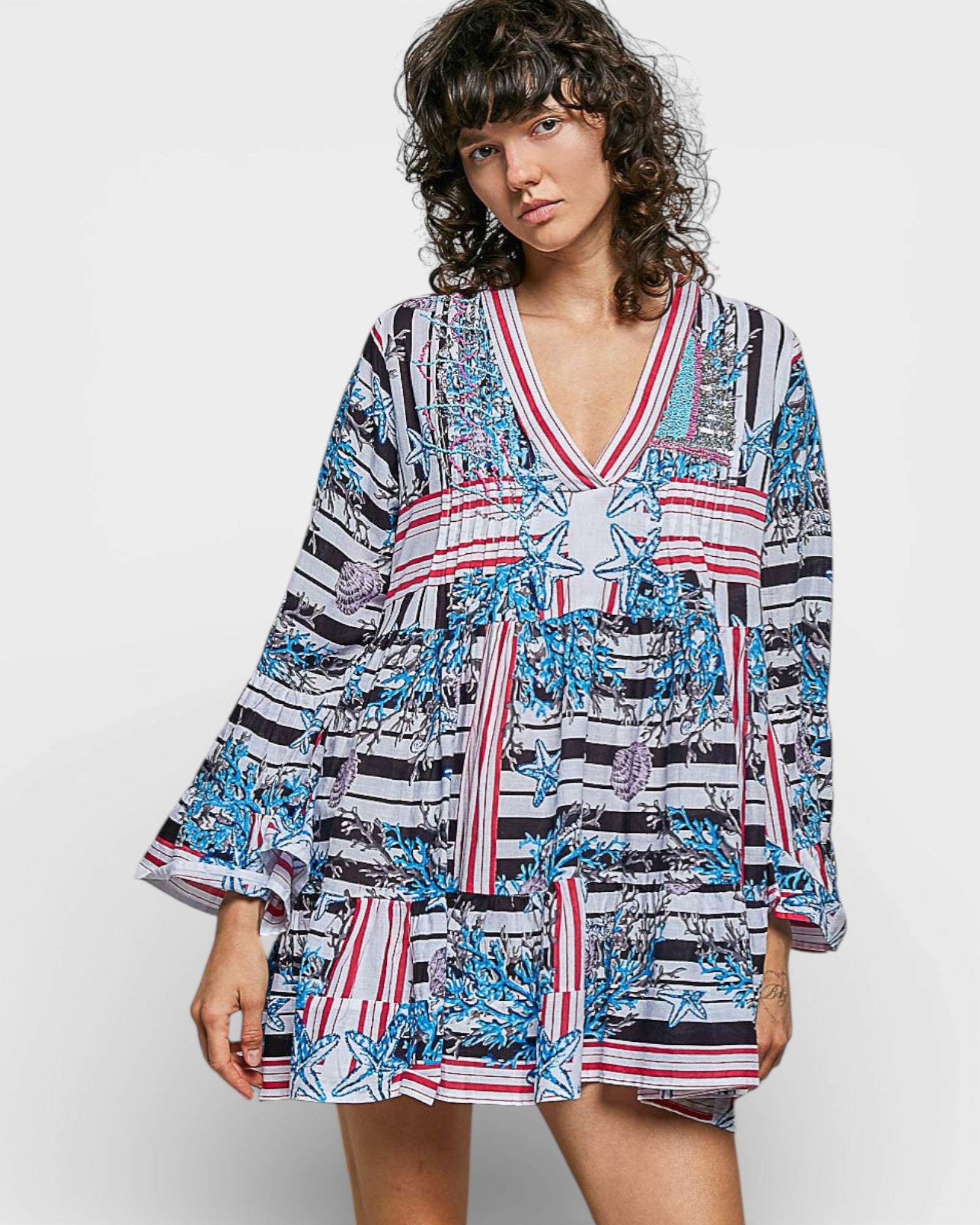 Woman wearing a colorful patterned dress on a white background