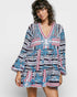 Woman wearing a colorful patterned dress on a white background