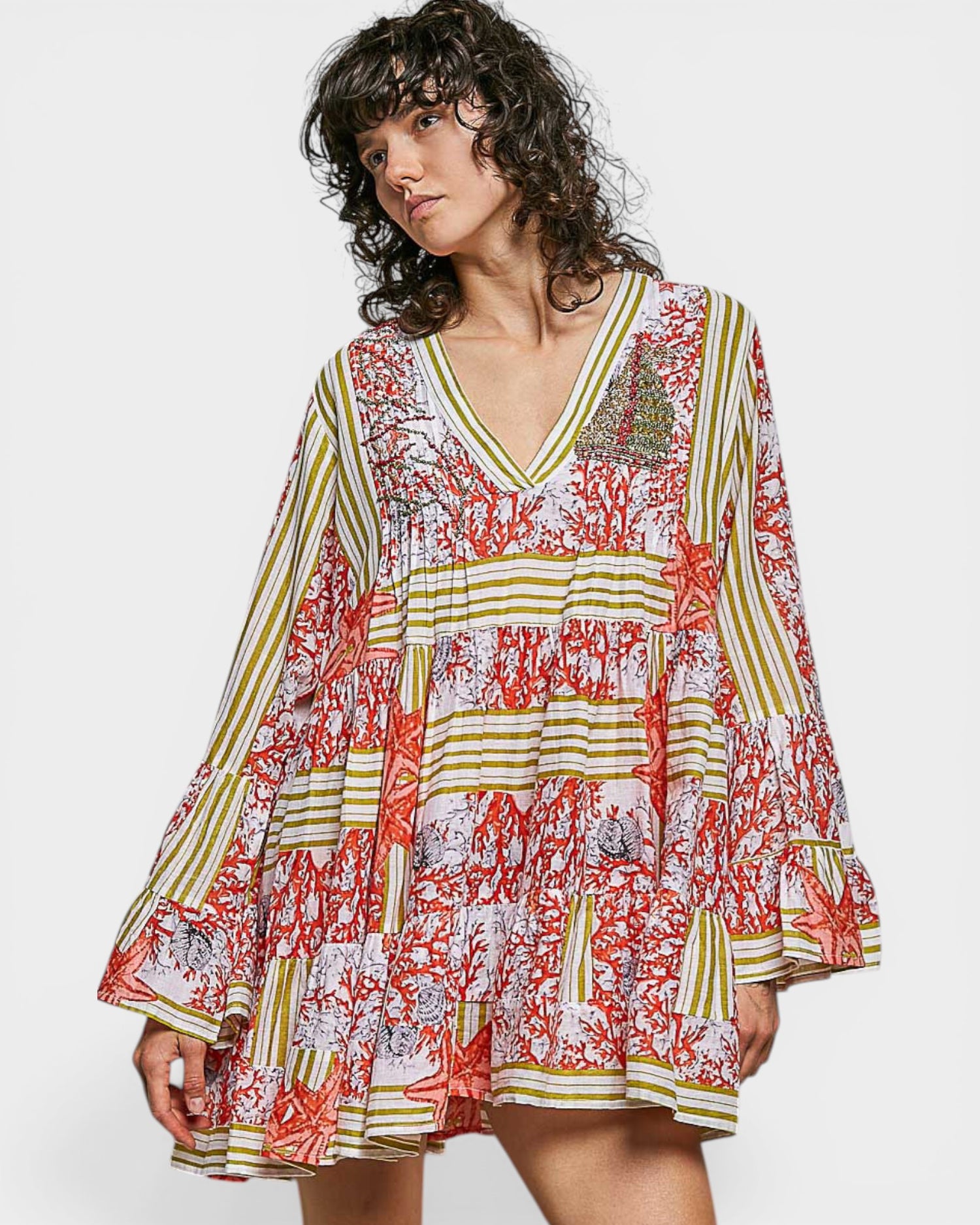 Woman wearing a colorful patterned dress on a white background