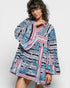 Woman wearing a patterned dress with a scarf on a white background