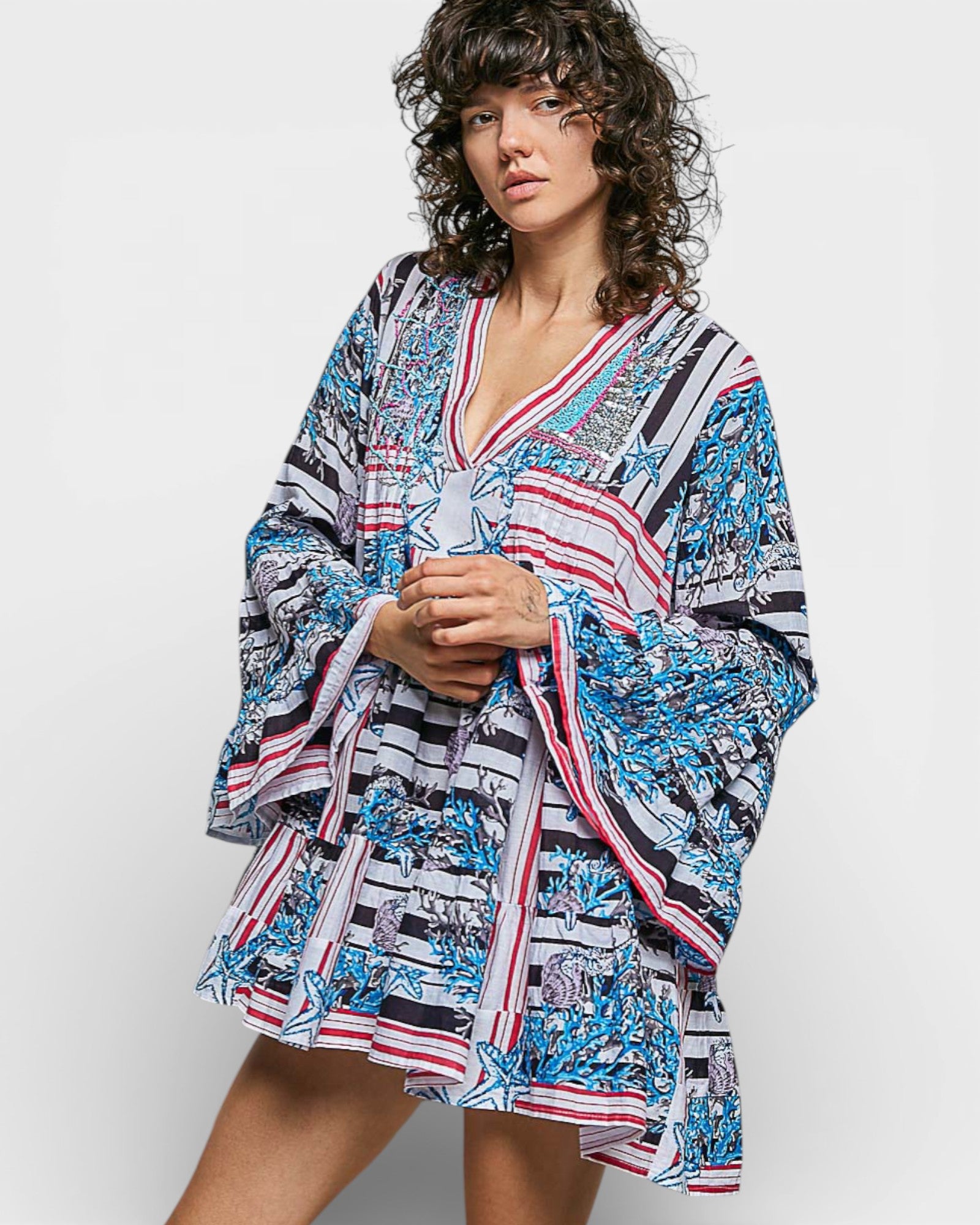 Woman wearing a colorful patterned dress on a white background