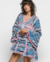 Woman wearing a colorful patterned dress on a white background