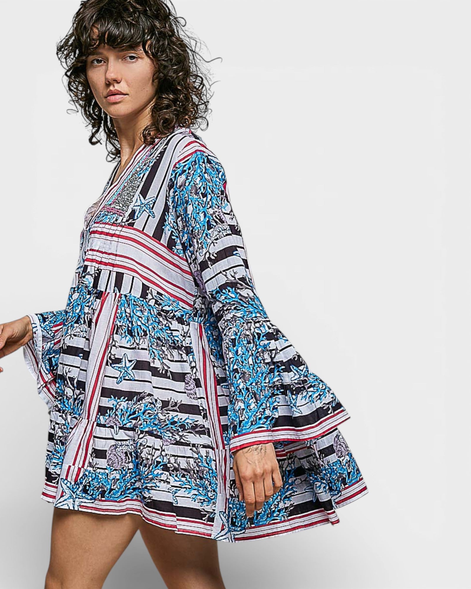 Woman wearing a colorful dress with a pattern on a white background