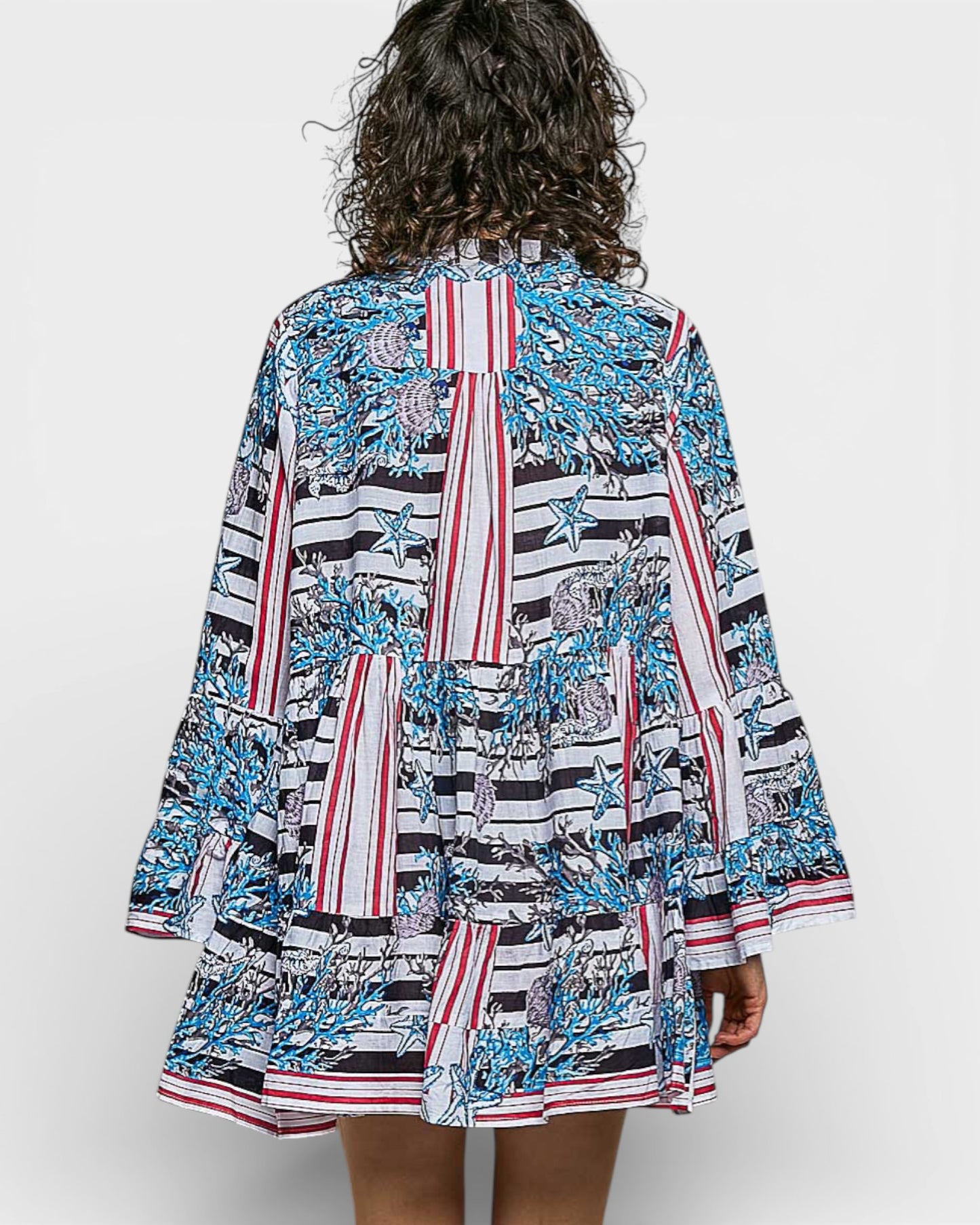 Woman wearing a colorful patterned dress on a white background