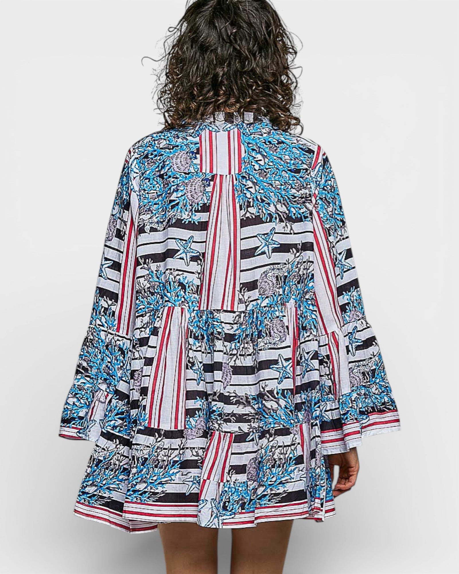 Woman wearing a colorful patterned dress on a white background