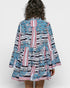 Woman wearing a colorful patterned dress on a white background