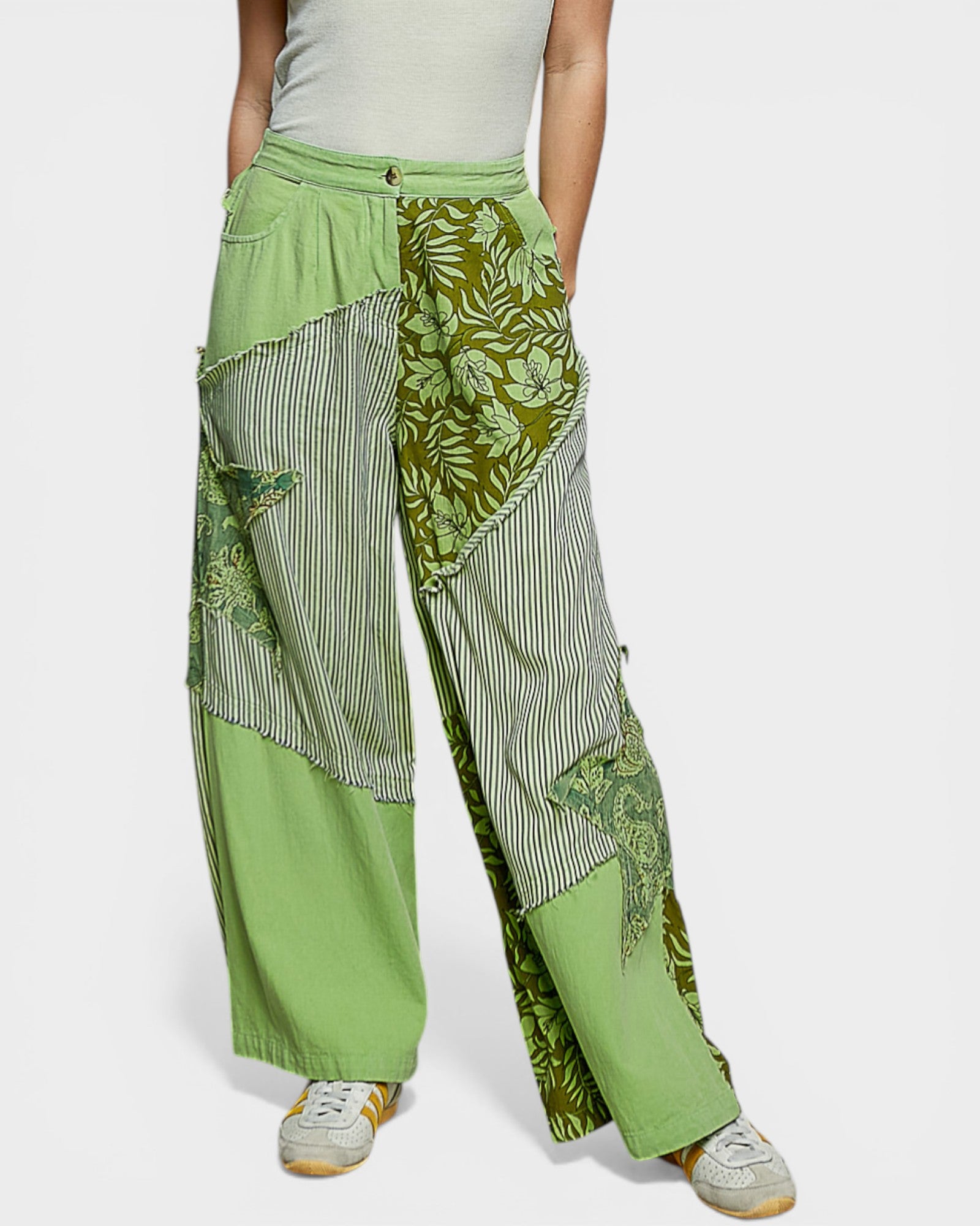 Green patchwork pants worn by a person on a white background
