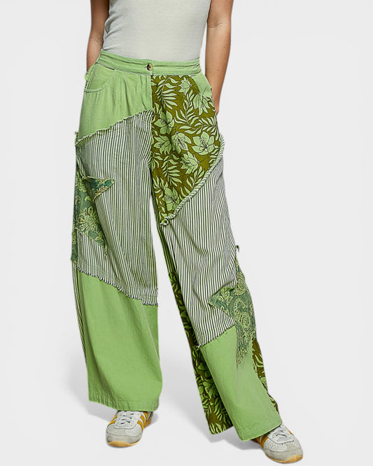 Green patchwork pants worn by a person on a white background