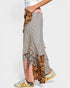 Person wearing a patchwork skirt with various patterns on a white background