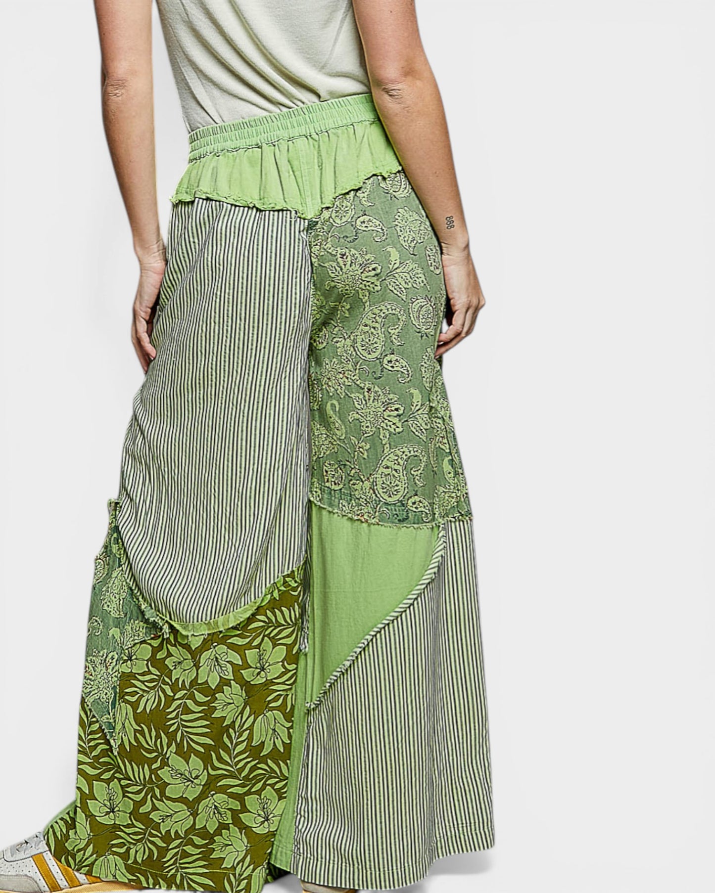 Green patchwork skirt worn by a person on a white background