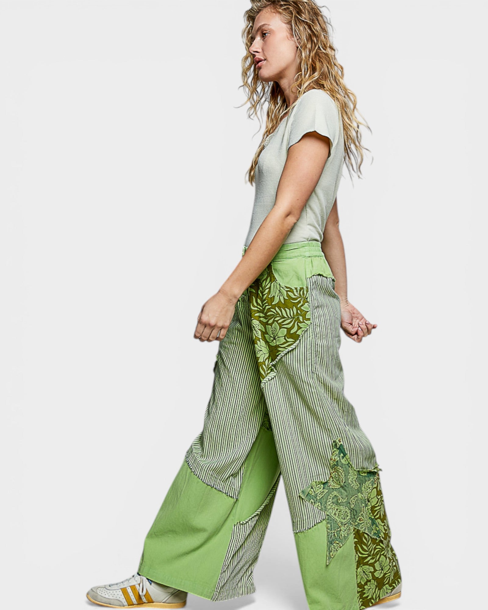 Woman wearing a green patchwork outfit on a white background