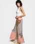 Woman wearing a white top and patterned pants on a white background