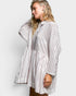 Woman wearing a striped shirt dress against a white background