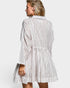Woman wearing a white and black striped dress on a plain background