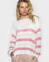 Woman wearing a white sweater with pink and beige stripes on a plain background