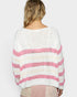 Woman wearing a white and pink striped sweater on a plain background