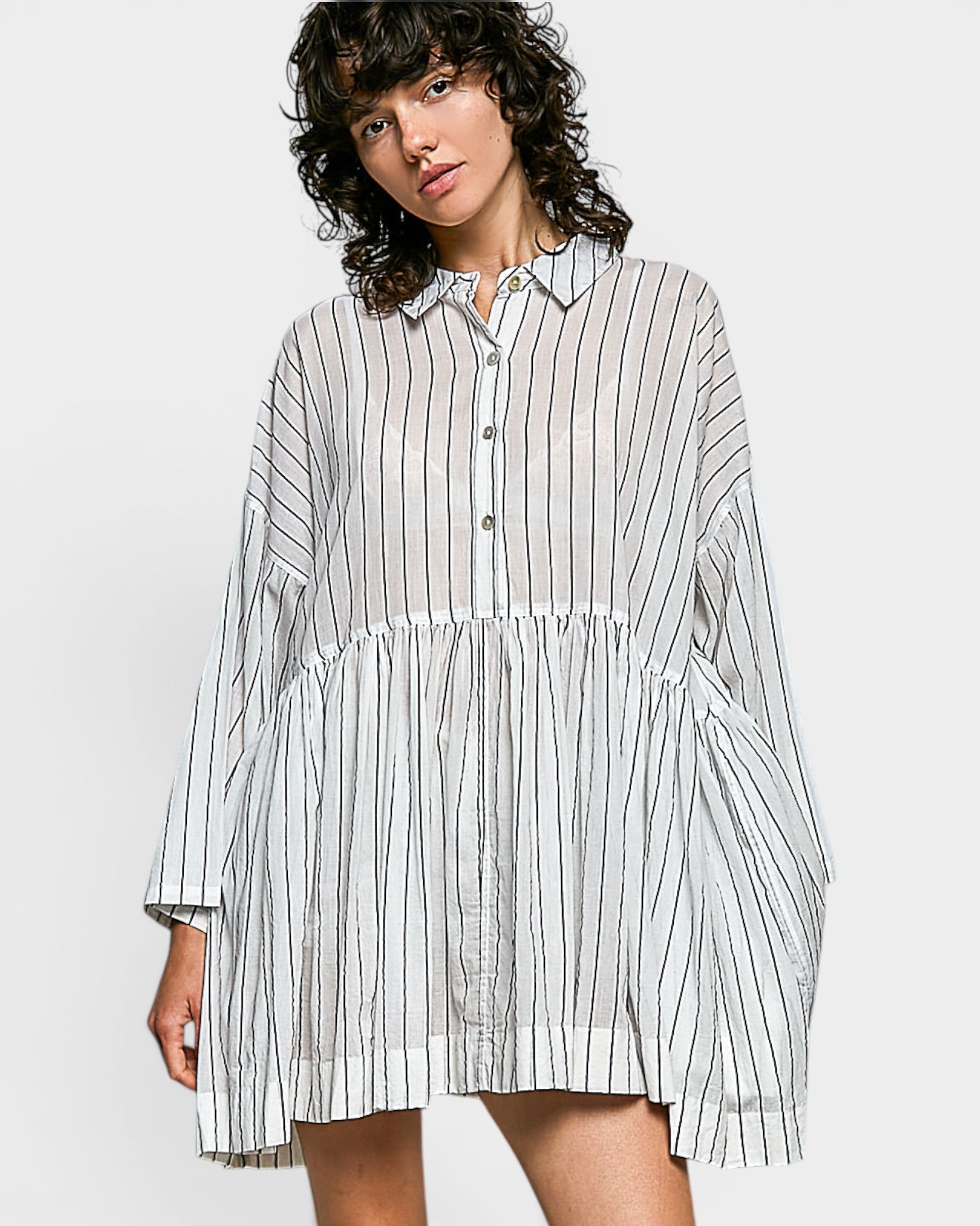 Woman wearing a striped shirt dress on a white background