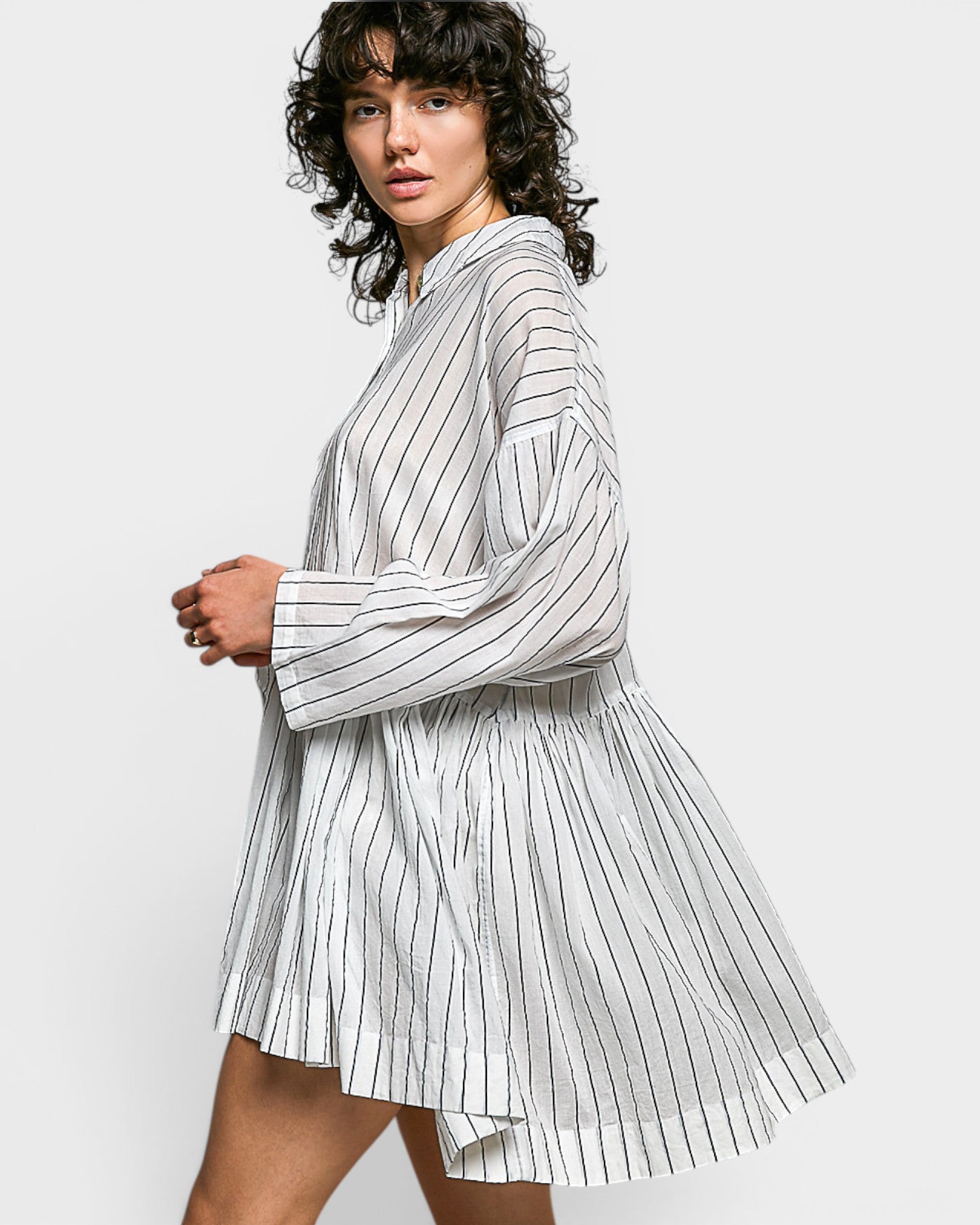 Woman wearing a white and navy striped dress on a white background