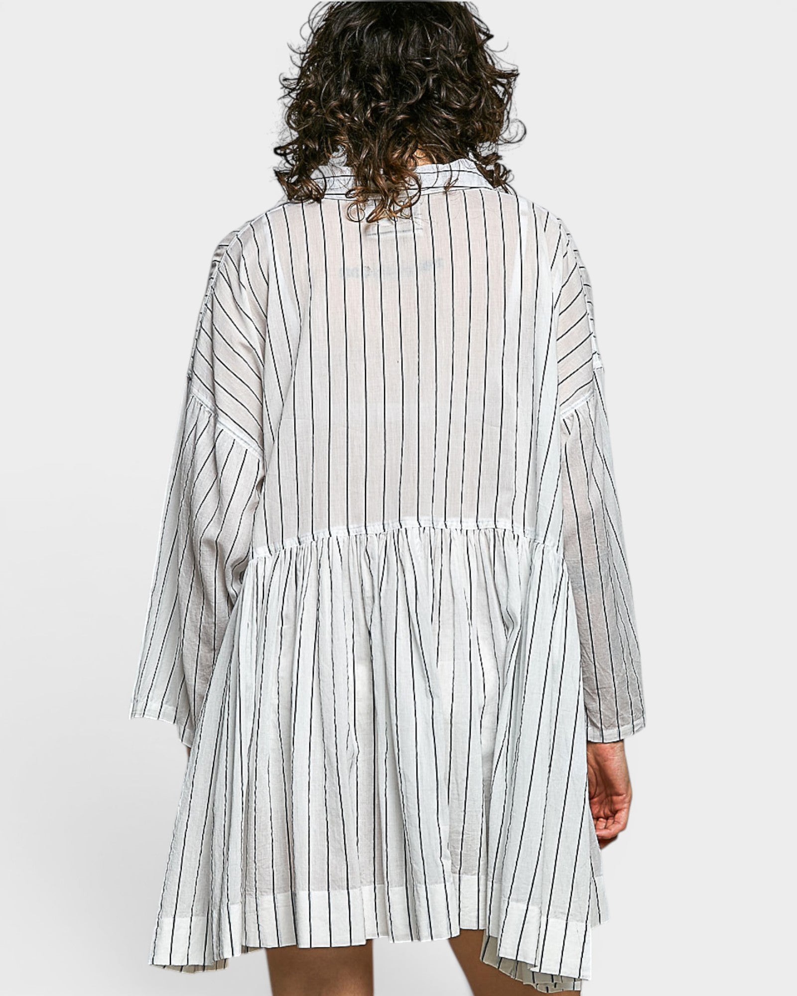Person wearing a white and navy striped dress on a white background