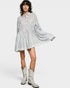 Woman wearing a striped dress and cowboy boots on a white background