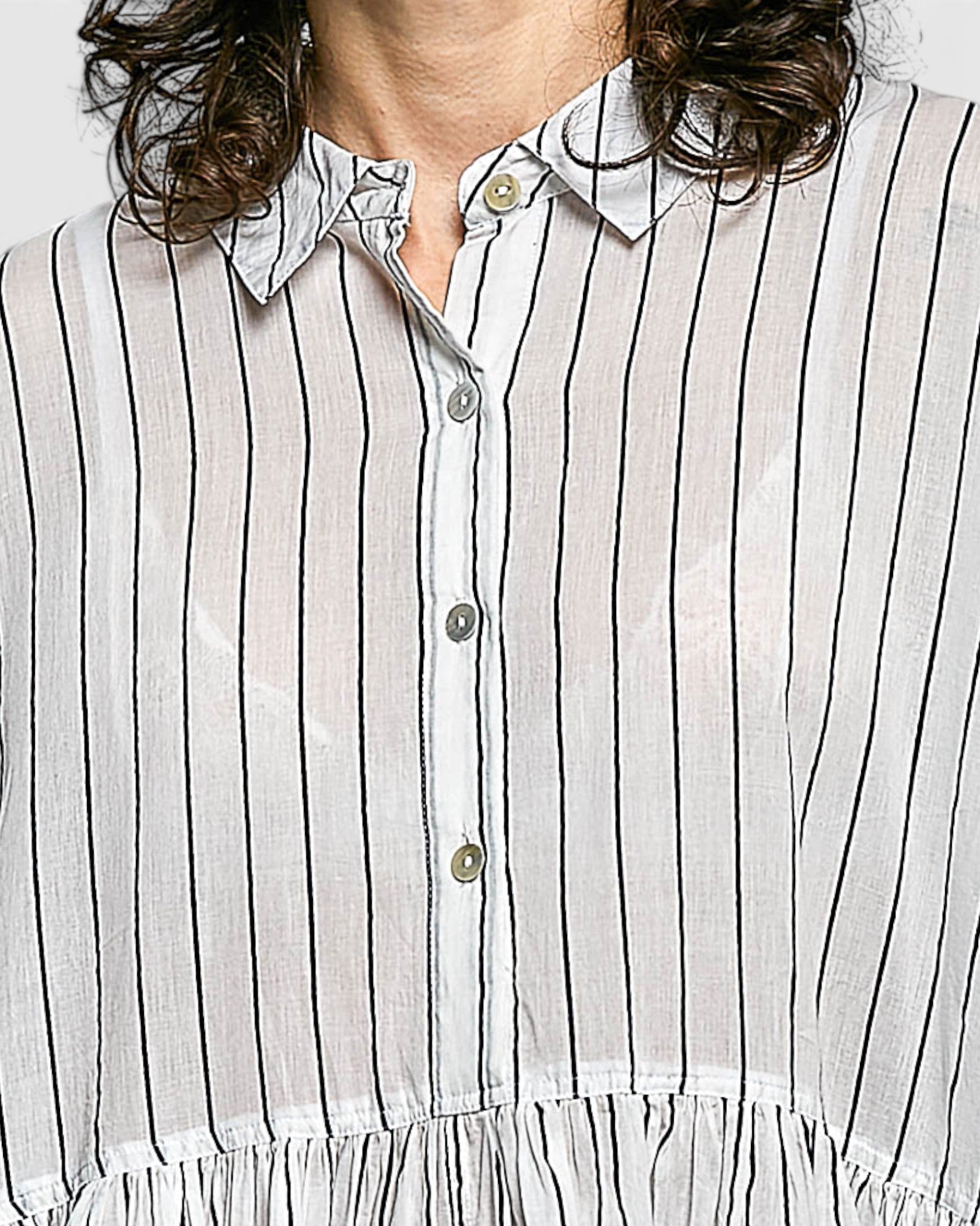 Close-up of a person wearing a white shirt with navy vertical stripes.